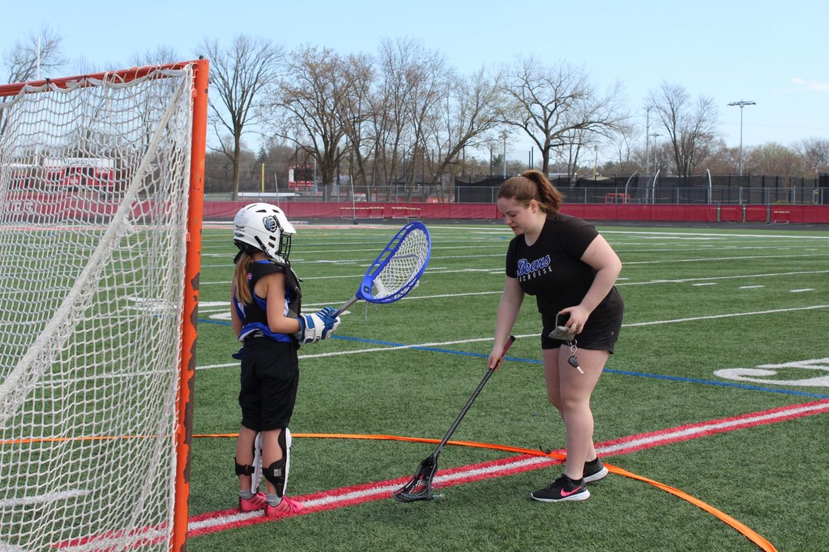 Karstenson teaches a young lacrosse player how to be a goalie. Karstenson has been coaching youth lacrosse for nearly four years.