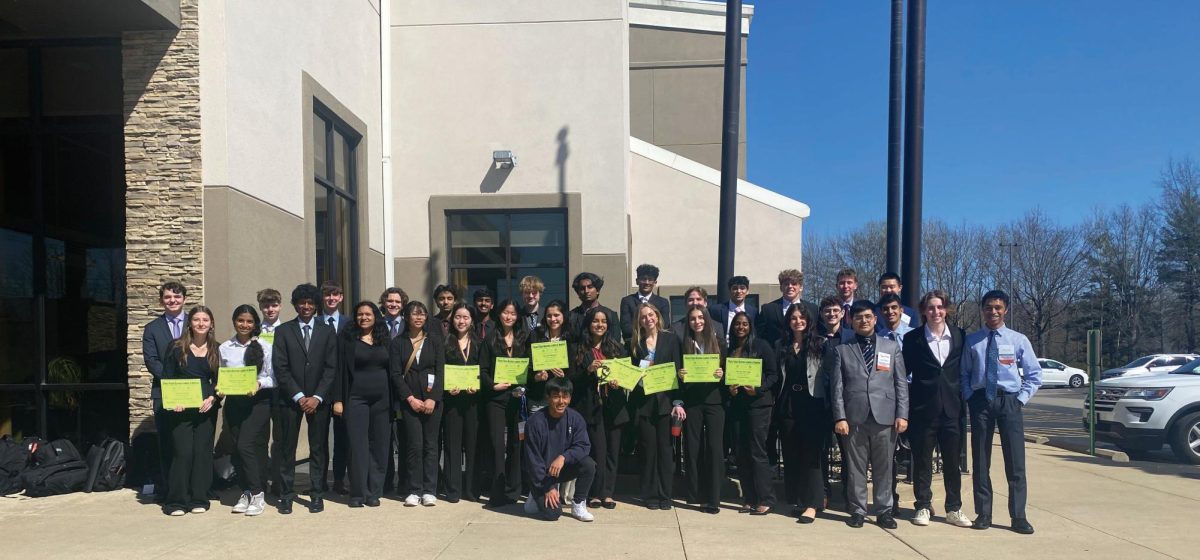 Students+pose+in+front+of+the+FBLA+state+competition+in+Springfield%2C+Illinois+on+April+6.+The+students+with+the+green+certificates+placed+at+the+competition+and+seven+of+these+students+will+compete+at+Nationals+after+qualifying+in+their+respective+events+at+state.