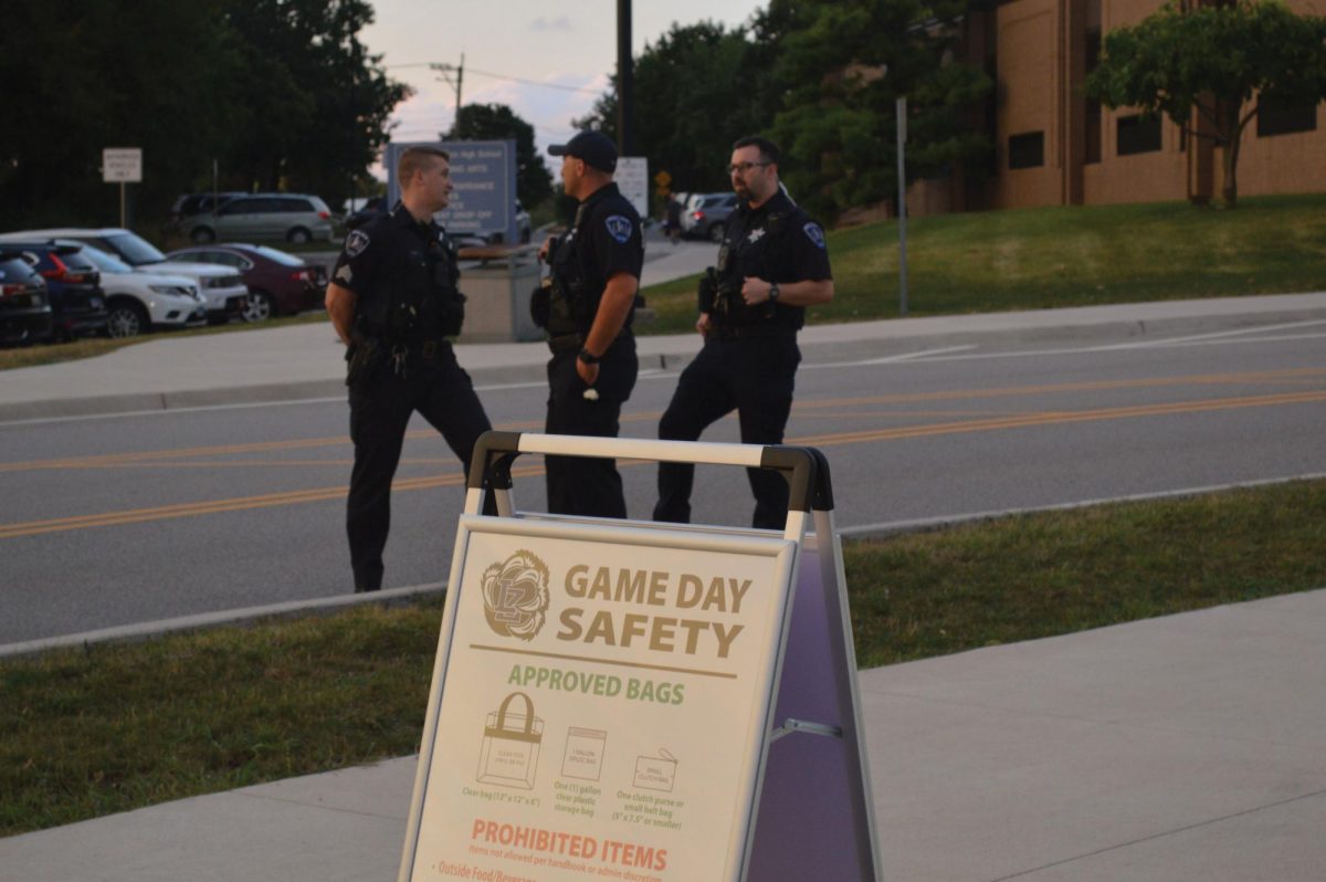 Police officers patrol a football game at LZ, with a sign displaying the new “Game Day Safety” polices set up a few meters away. The new polices require football game attendees to bring either see-through or miniature bags 