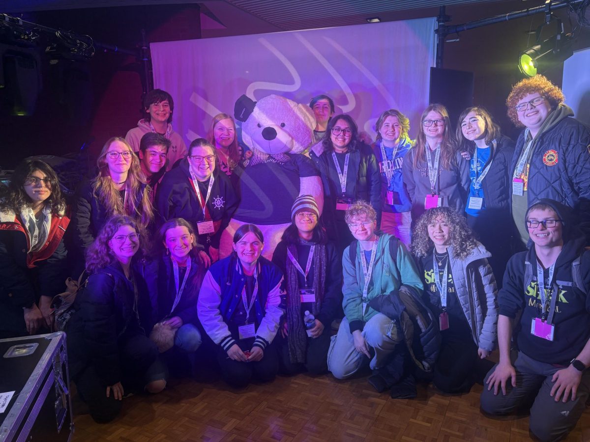 Members of technical theatre club and drama club pose for a photo; Zukowski is pictured to the left of the bear and Kinsey is pictured a person over. Theatre Fest's location at the University of Illinois offered many resources for LZHS students to use, such as their own Performing Arts Center.